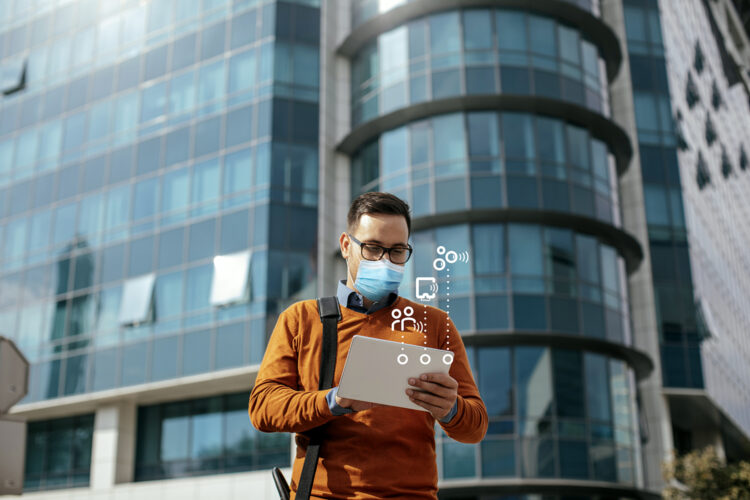 Successful Modern Young Businessman Using a Digital Tablet on the Street