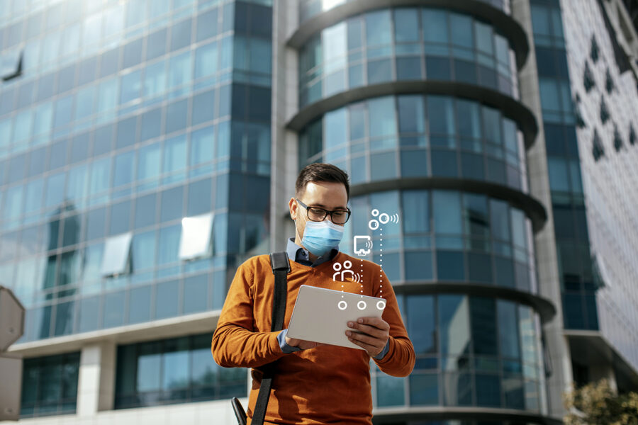 Successful Modern Young Businessman Using a Digital Tablet on the Street