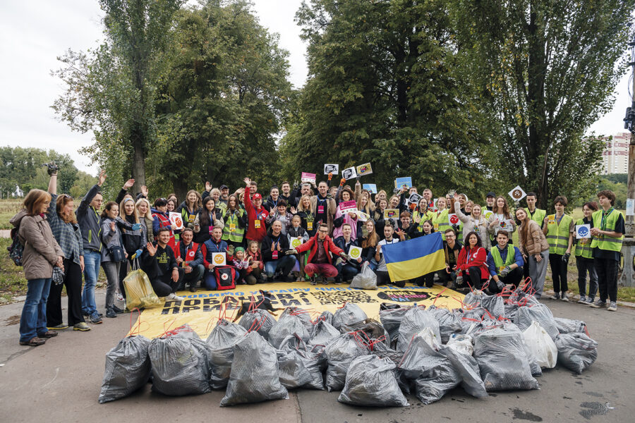 personas y bolsas de basura cerradas llenas de residuos