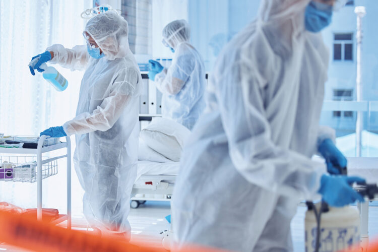 Biohazard team sterilise a hospital room together. Science team cleaning a medical center together. Medical team use antiseptic to clean a hospital. csi colleagues santise a hospital